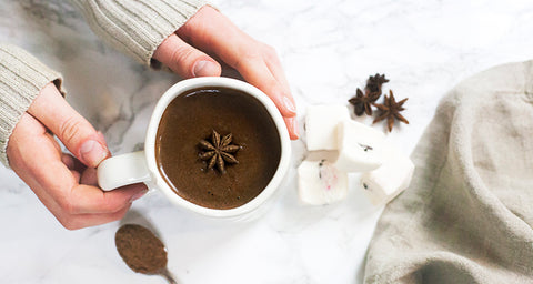 adaptogen hot chocolate recipe with nature restore reishi powder - hands holding hot chocolate mug